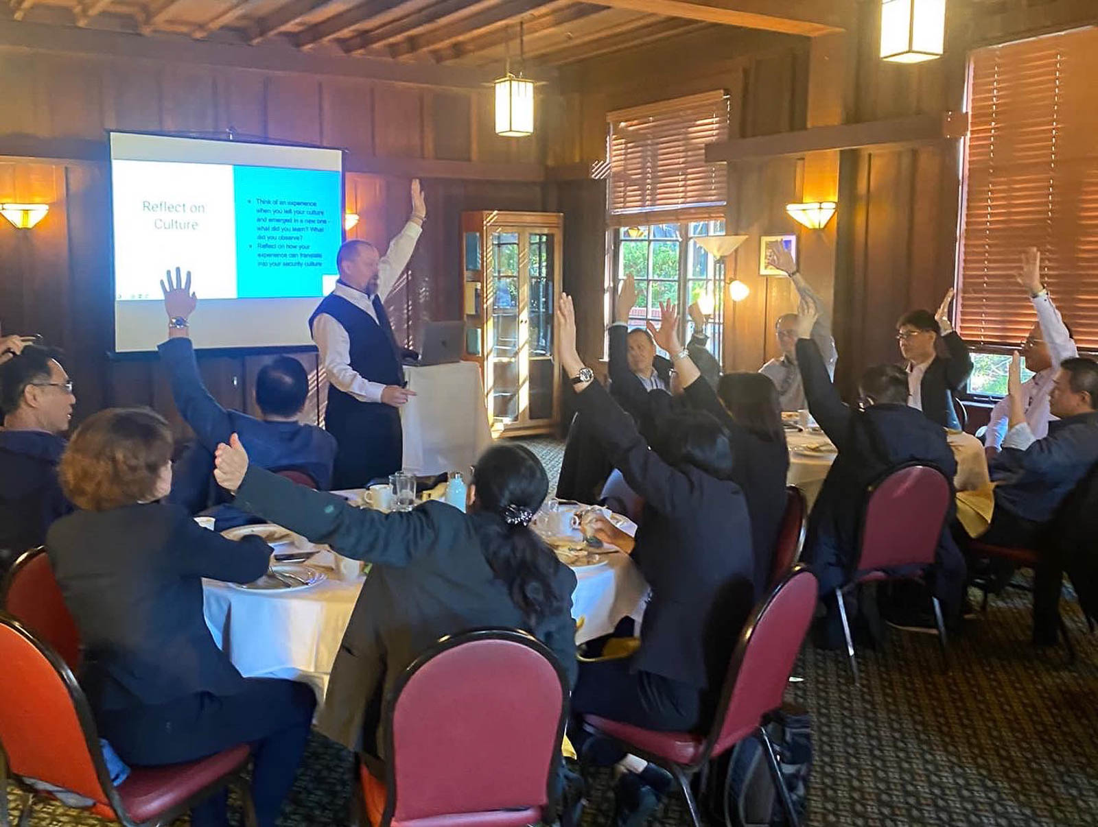 Kai leading an interactive workshop — audience engaged with hands raised